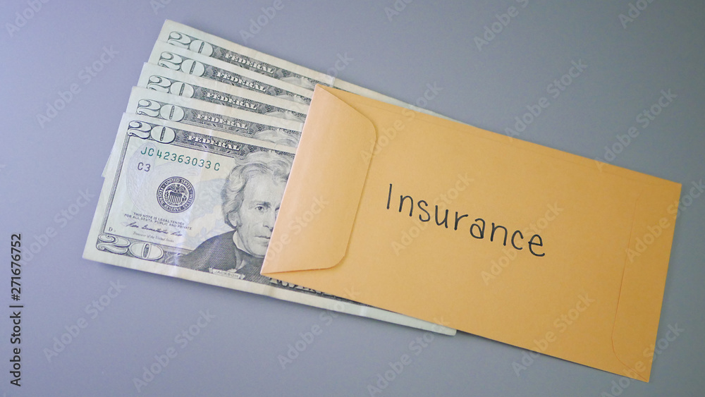 A yellow envelope on a gray table, containing cash for insurance. A yellow envelope on a gray table, containing cash for insurance.
