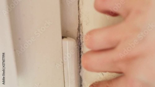 A woman's hand runs along the old dirty window slope. Show black mold Aspergillus closeup. Real time, contains people, natural light