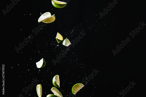 lime slice on black background with water drops