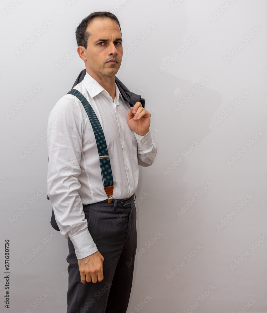 man standing in formal clothes, suspenders making poses with his suit  (photo 1/6) Stock Photo