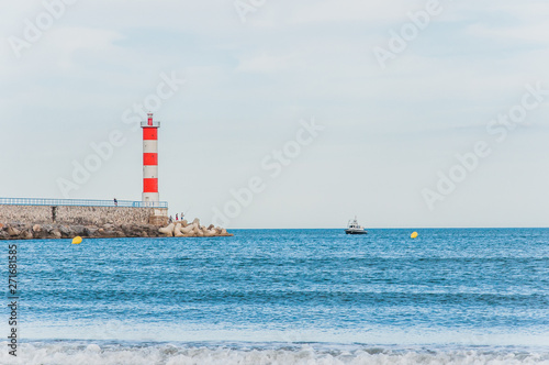 Lighthouse of Port-La-Nouvelle in red and white on cloudy sky