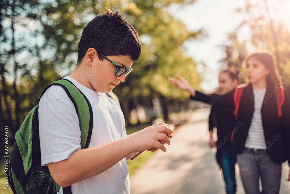 Obraz premium Boy using smart phone at schoolyard