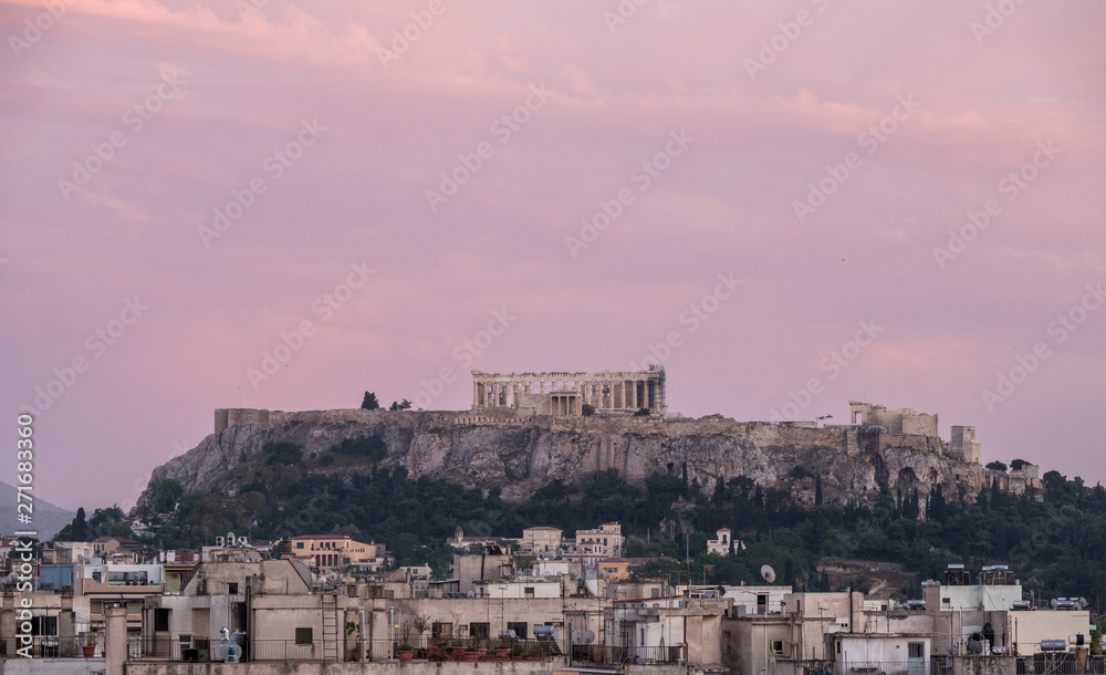 Acropolis hill at sunset or dusk with the city of Athens surrounding it