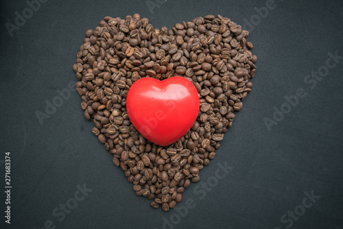 heart of coffee beans on red background