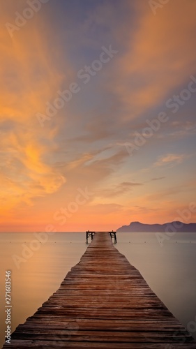 Wooden pier / jetty, playa de muro, Alcudia, sunrise, mountains, secluded beach, golden sunlight, reflection, beautiful sky, clouds,landmark, mallorca, spain. © gaz