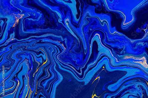 Hand painted background with mixed liquid blue and golden paints. Abstract fluid acrylic painting. Modern art. Marbled blue abstract background. Liquid marble pattern
