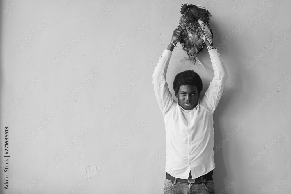 African American Man Holding Chicken Above His Head In Studio Dark African American Man Holding Chicken Above His Head In Studio Dark