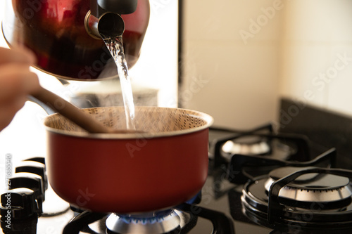putting boiled water to cook rice