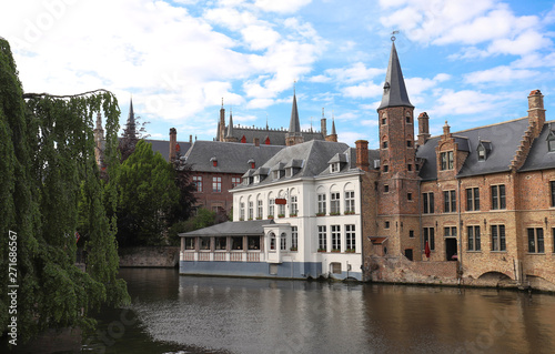 Scenic city view of Bruges canal with beautiful medieval colored houses and reflections.
