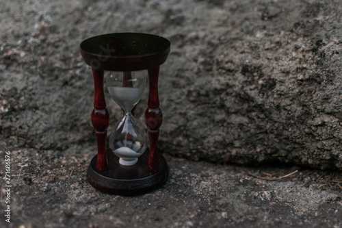 Hourglass on a stone in the dark. © Konstiantyn Zapylaie