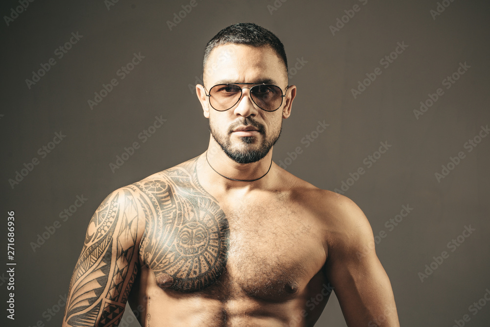 Muscular macho man with athletic body in sunglasses. brutal sportsman  torso. steroids. sport fitness, health. sexy abs of tattoo man. male  fashion. confidence charisma. Stock Photo | Adobe Stock