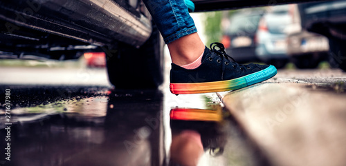 Girl stepping out of the car and avoiding puddle