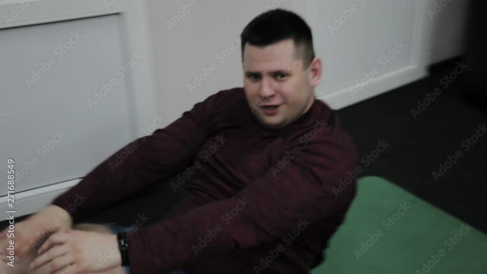 An overweight adult man trains a press at the gym An overweight adult man trains a press at the gym