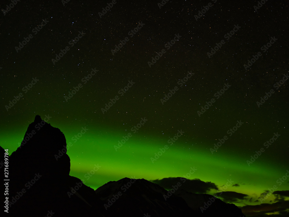 Aurora Borealis hinter einer Bergkette in Island