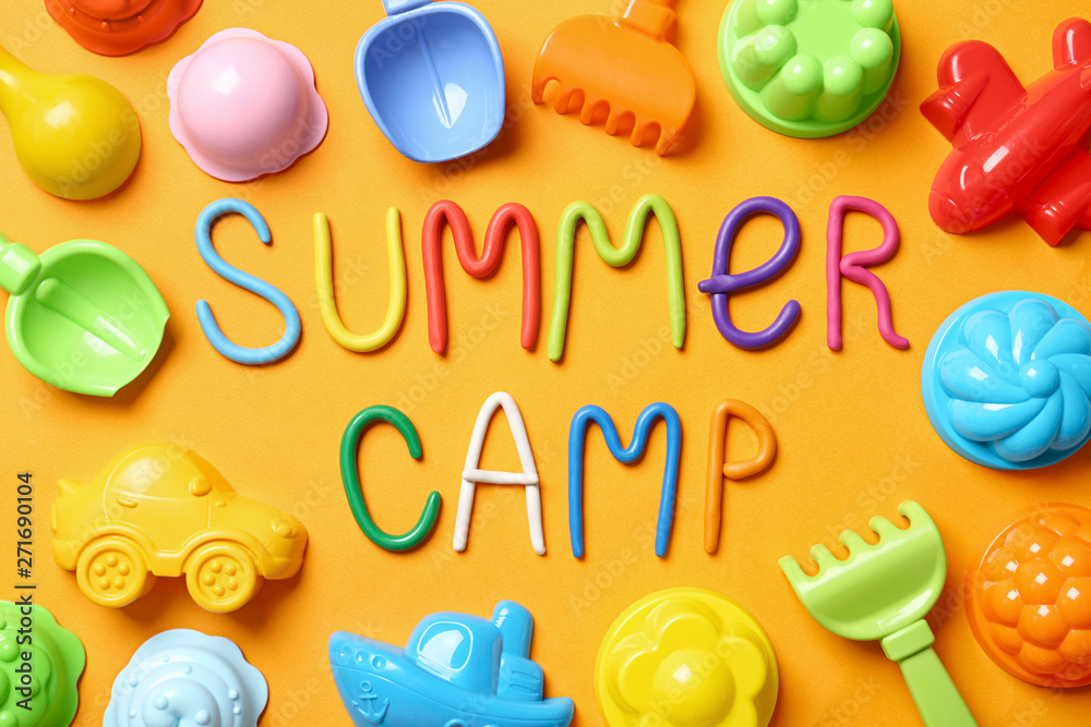 Text SUMMER CAMP made of modelling clay and different sand molds on color background, flat lay