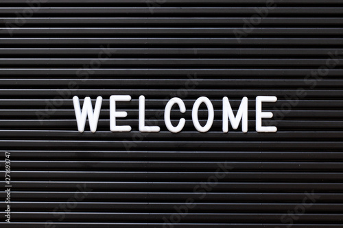 Black color felt letter board with white alphabet in word welcome background