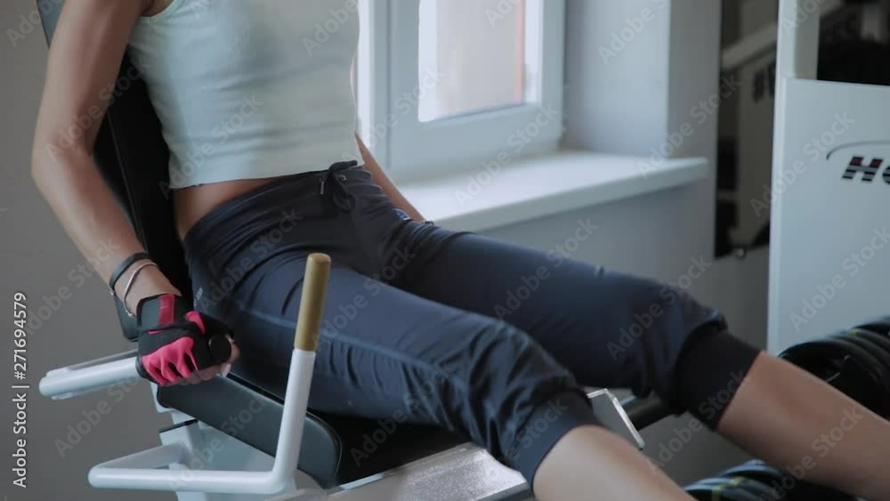 Beautiful active woman shakes legs on the gym at the gym. Beautiful active woman shakes legs on the gym at the gym.