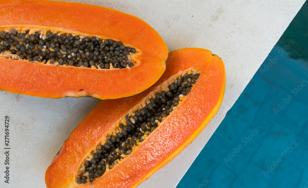 Fresh orange papaya on a stone background near waterpool. Tropical Fruit. Top view. Free text space. Fresh orange papaya on a stone background near waterpool. Tropical Fruit. Top view. Free text space.
