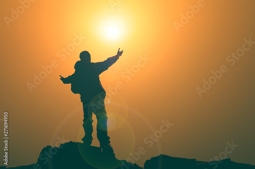 Man with arms extended toward heaven at sunrise ,pay respect prayer concept for faith spirituality