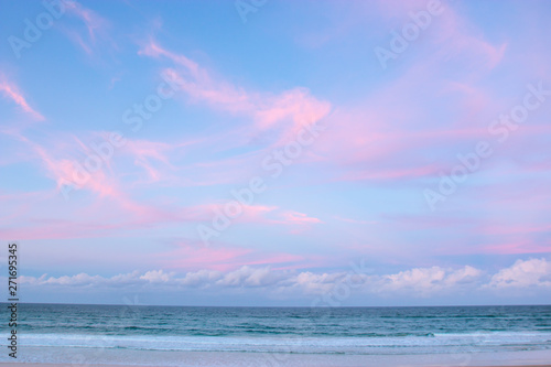 pretty pastel colour sky pink purple blue with fluffy cloud on beach with white sand Australia Gold Coast