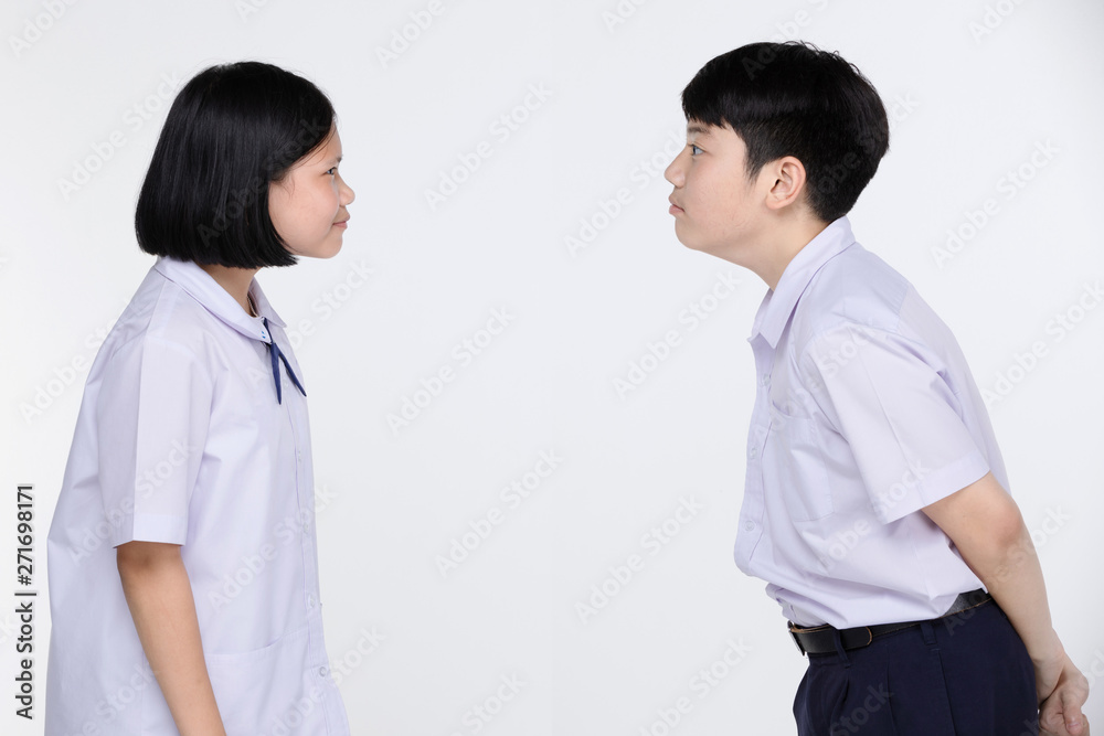 Aasian girl and boy in student's uniform on gray background. Aasian girl and boy in student's uniform on gray background.