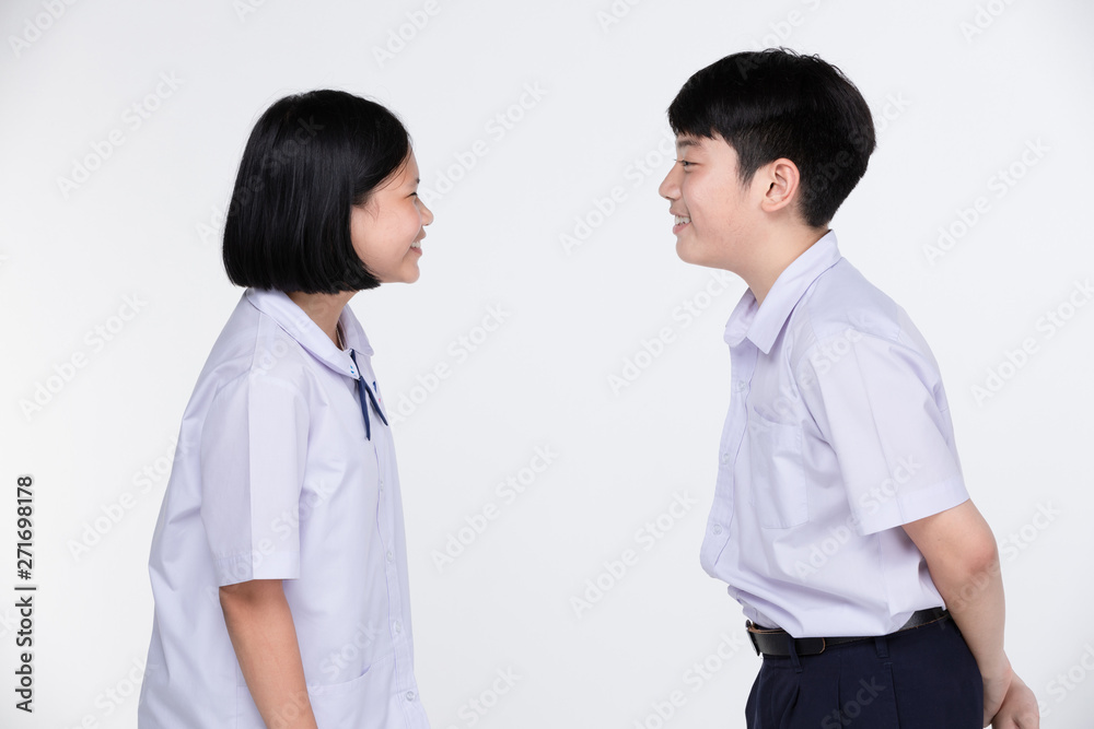Aasian girl and boy in student's uniform on gray background. Aasian girl and boy in student's uniform on gray background.