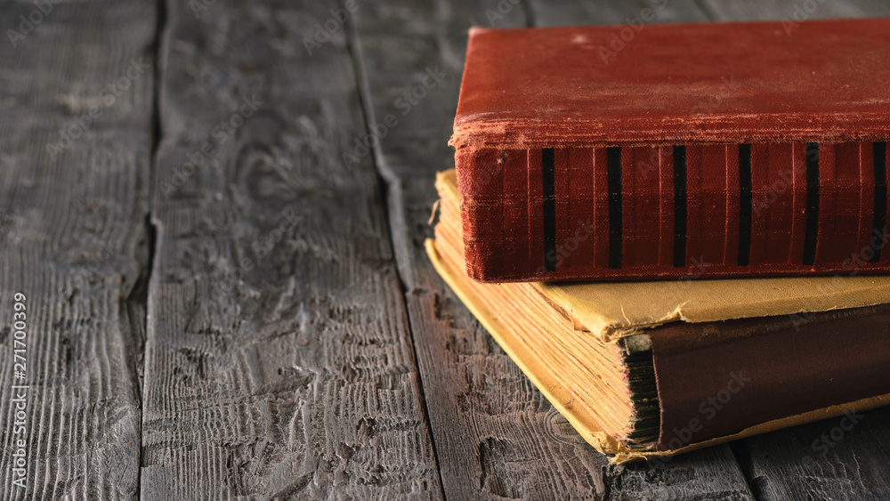 Two very old books on a black wooden table. Two very old books on a black wooden table.