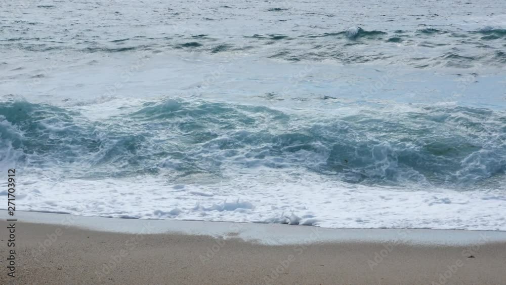 Rough white waves crashing on sandy beach. Straight on shot. Rough white waves crashing on sandy beach. Straight on shot.