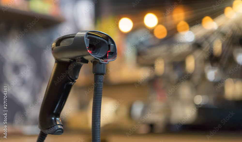 Close up barcode scanner in hand on blurred background,Inspection of goods in the warehouse,The concept of selling products in a supermarket,Spot focus,Copy space. Close up barcode scanner in hand on blurred background,Inspection of goods in the warehouse,The concept of selling products in a supermarket,Spot focus,Copy space.