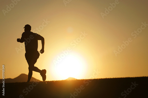 silhouette of man running at sunset