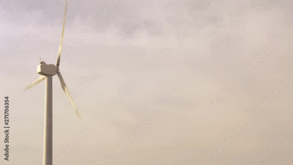 Wind turbine rotate on a sky background with clouds. Energy production with renewable energy. Wind turbine rotate on a sky background with clouds. Energy production with renewable energy.