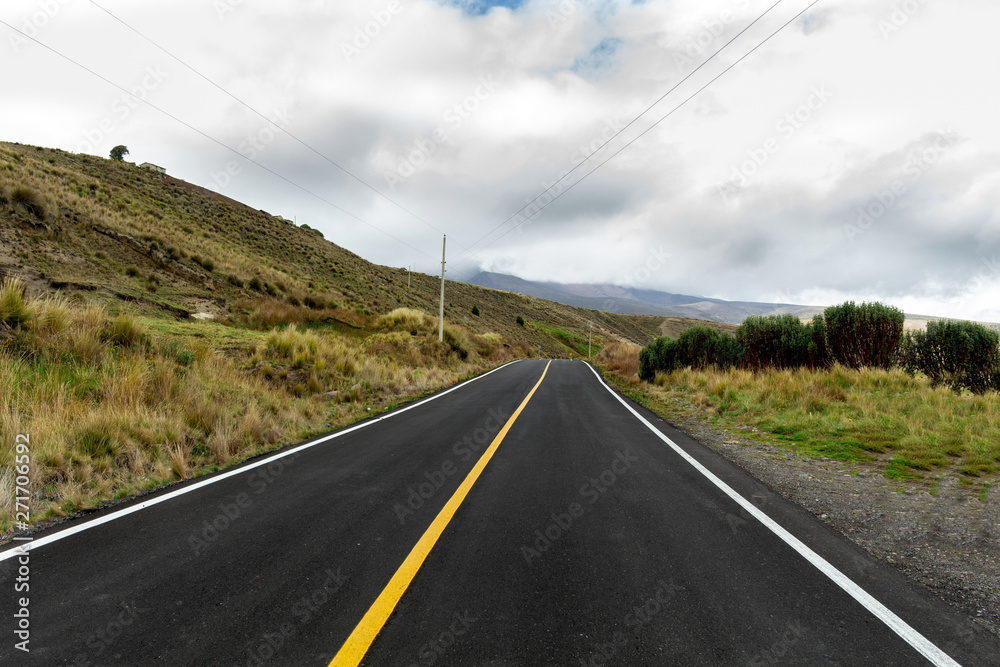 rural highway in the middle of a mountain with cloudy sky