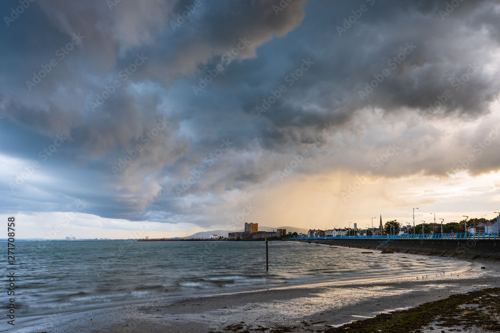 Large storm clouds gather over Carrickfergus Castle, County Antrim, Northern Ireland 