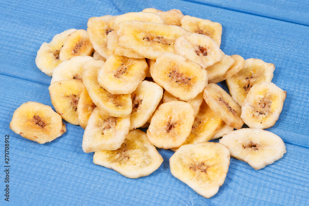 Dried banana chips for snack or dessert on blue boards