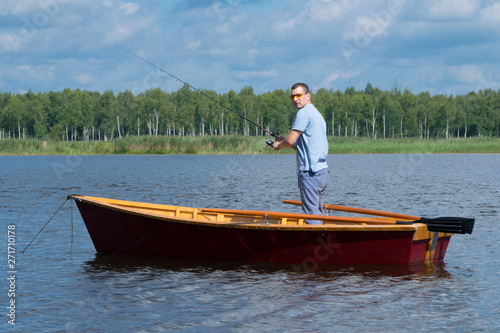 man resting on the lake, boating with oars and fishing with a fishing rod