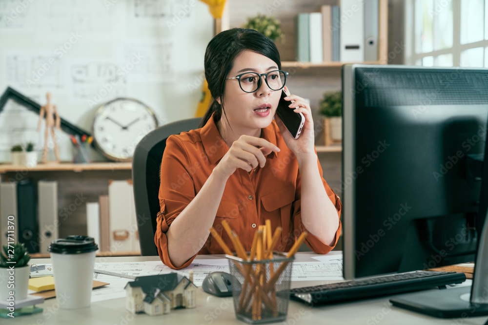 Φωτογραφία busy asian woman architect sitting in modern cozy bright office