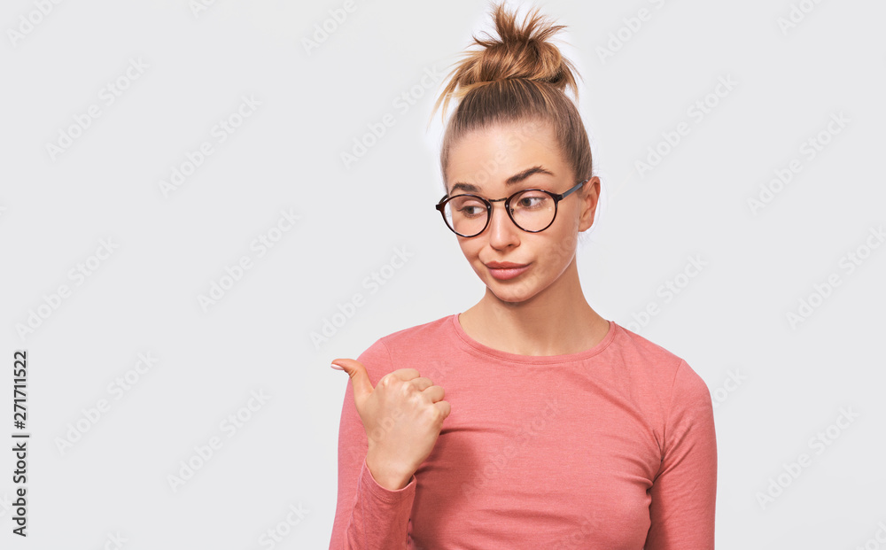 Φωτογραφία Studio portrait of pretty young woman frowning puzzled faces, weraing pink long sleeve blouse