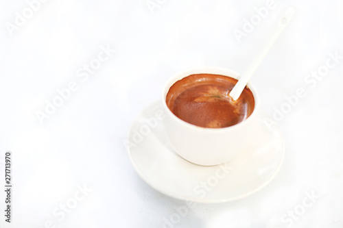 Overhead view of a freshly brewed mug of espresso coffee on white table