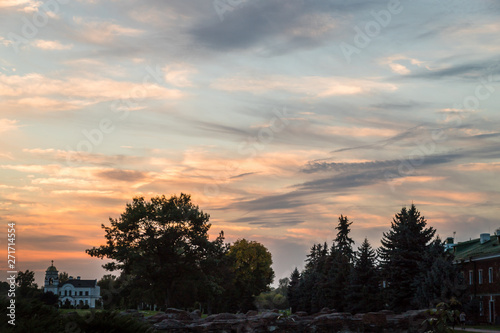 Beautiful sky with clouds at sunset over the roofs of houses in village