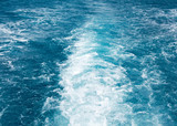 Travel destination motor boat water traces in open caribbean sea.