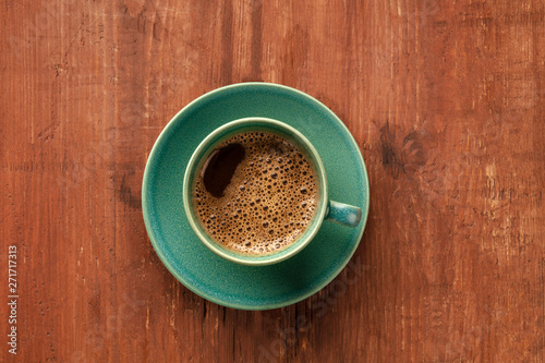 A cup of black coffee on a dark rustic wooden background  shot from the top with a place for text