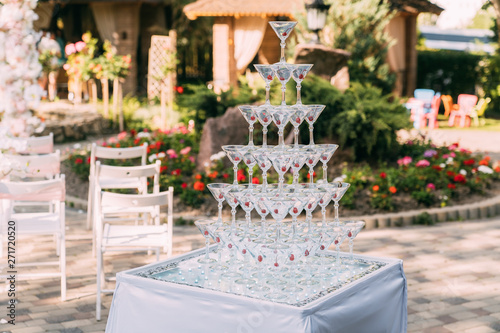 Glasses for alcoholic beverages. Pyramid made of champagne glasses with cherry