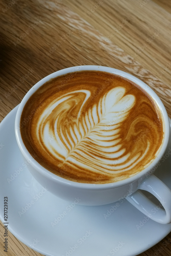 Heart shape foam drawed on hot fresh coffee latte art on wooden table at vintage cafe. Heart shape foam drawed on hot fresh coffee latte art on wooden table at vintage cafe.