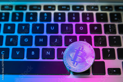 Circle Bitcoin coin on top of computer keyboard buttons. Digital currency, block chain market, online business photo