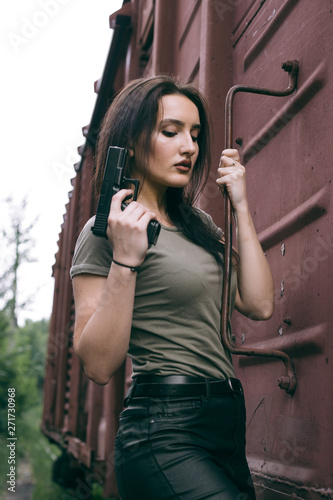 Powerful Woman Holding Gun Action Movie Style. Train adventure. Military girl with .