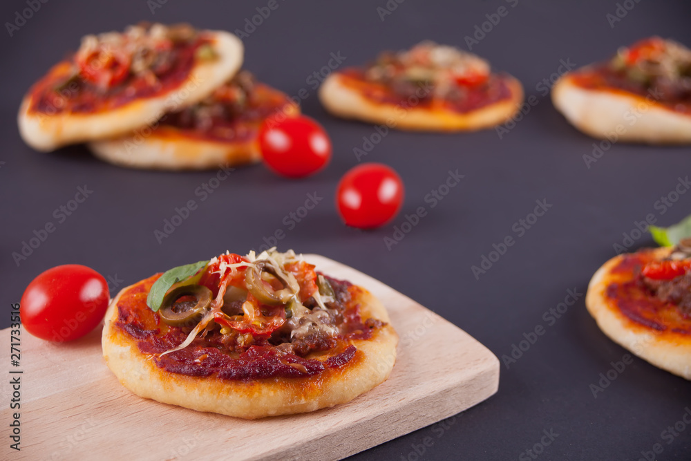 Homemade mini pizza on the black background. Homemade mini pizza on the black background.