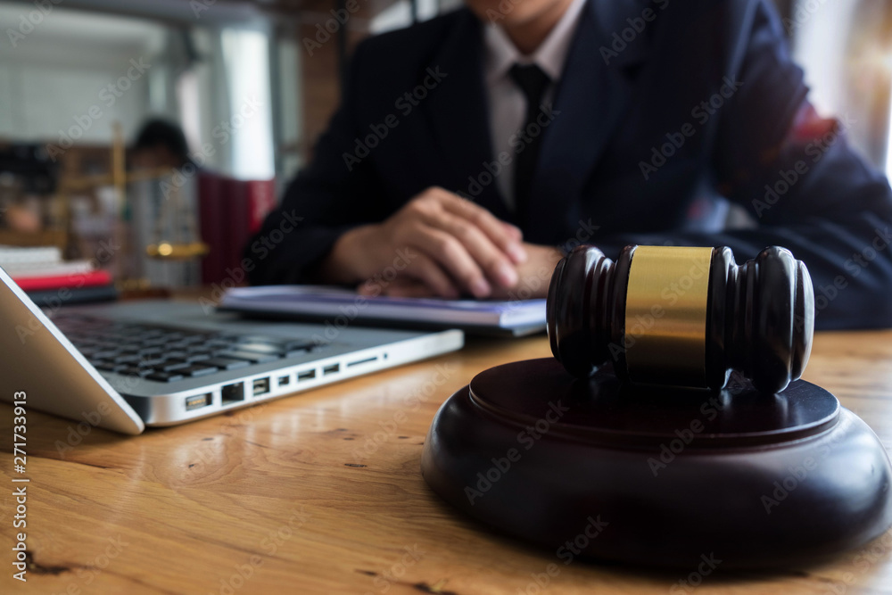 justice and law concept.Male judge in a courtroom the gavel,working with digital tablet computer on wood table. justice and law concept.Male judge in a courtroom the gavel,working with digital tablet computer on wood table.