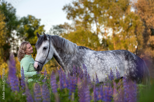 Happy woman with a beatiful grey horse 