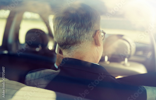 transport, business trip, technology and people concept - senior businessman calling on smartphone and driving on car back seat © Syda Productions