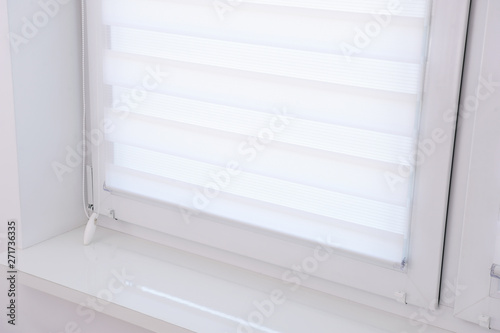 White roller blind on a metal plastic window